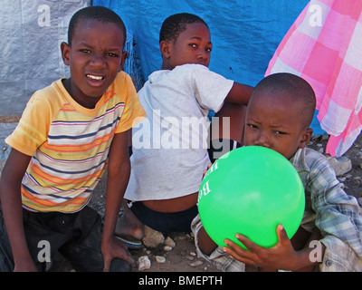 I bambini giocano con un palloncino in un campo per sfollati dal 2008 stagione degli uragani di Gonaives, Haiti Foto Stock