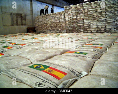 I lavoratori si muovono i sacchi di aiuti alimentari donati da il Brasile e la Francia in un programma alimentare mondiale warehouse in Gonaives, Haiti Foto Stock