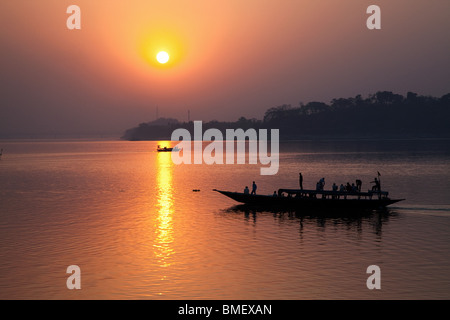 Tramonto sul fiume Brahmaputra con passaggio nave passeggeri, Guwahati, Stato di Assam, in India Foto Stock