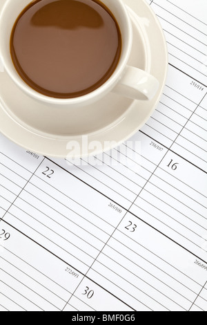 Tazza di caffè e calendario close up Foto Stock