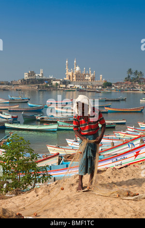 India Kerala, Kovalam, villaggio Vizhinjam fisherman tendente al suo reti da pesca Foto Stock