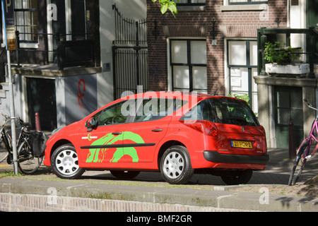 Un verde di ruote per auto car sharing, incontri, noleggio a breve termine, su un canale di Amsterdam. Peugeot 207. Foto Stock