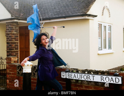 Giovane donna di essere soffiata via dal forte vento in appropriatamente chiamato beaufort road in Portsmouth Inghilterra Foto Stock