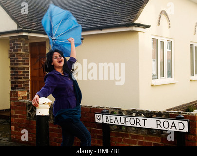 Giovane donna di essere soffiata via dal forte vento in appropriatamente chiamato beaufort road in Portsmouth Inghilterra Foto Stock