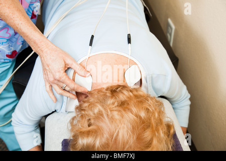 Chiropratica paziente ottenere la stimolazione elettrica per la terapia del suo dolore alla schiena. Foto Stock