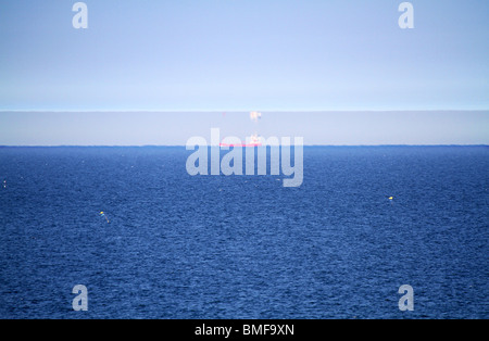 Mirage raro effetto sulla giornata molto calda con nave riflesso capovolto in temperatura dello strato di inversione nel cielo. Foto Stock