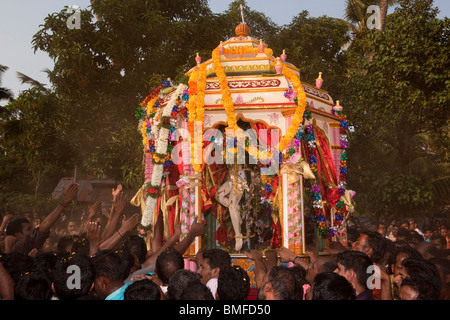 India Kerala, Alappuzha, (Alleppey) Arthunkal, festa di San Sebastian, pellegrini holding aloft processione icona crocifissione crepuscolo Foto Stock