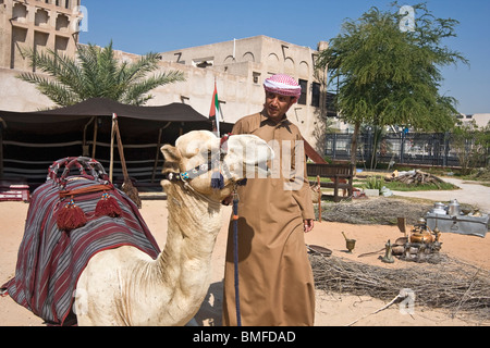 Arab bedouin l uomo con il suo cammello Al Bastakiya, zona storica di Dubai restaurata con gallerie d'arte, musei e caffè Foto Stock
