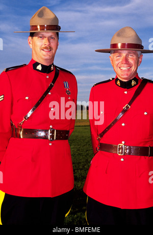 Due sorridente Royal Canadian polizia montata nel loro tradizionale rosso brillante Serge vestito giacche uniforme in New Brunswick, Canada. Foto Stock