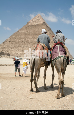 Due piloti del cammello e turisti nella parte anteriore della piramide di Khafre (Chephren) a Giza Egitto Foto Stock