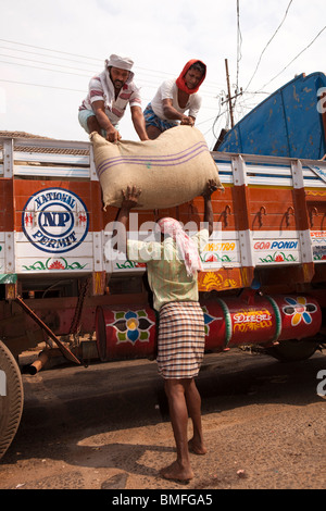 India Kerala, Calicut, Kozhikode, grande bazaar, gli uomini lo scarico dei sacchi di spezie provenienti da autocarro Foto Stock