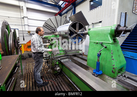 Un lavoratore anziano nell'industria del metallo con macchina CNC. Foto Stock