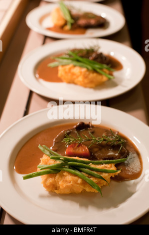 Brasato di manzo servita con purè di patate dolci e fagioli verdi a una cena formale a Santa Croce College di Oxford. Foto Stock