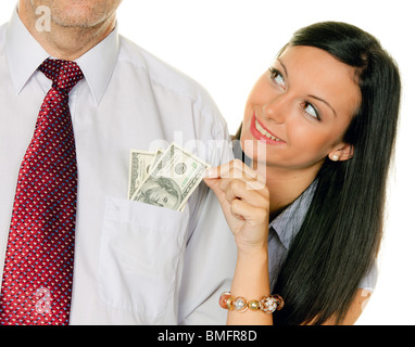 Una giovane donna tira il denaro al di fuori di un uomo di tasca. Dollaro Foto Stock