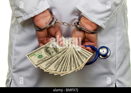 Un medico con banconote di dollari e manette Foto Stock