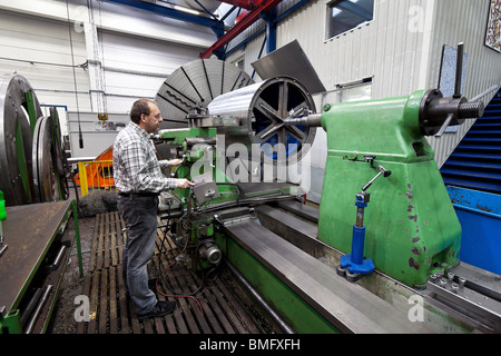 Un lavoratore anziano nell'industria del metallo con macchina CNC. Foto Stock