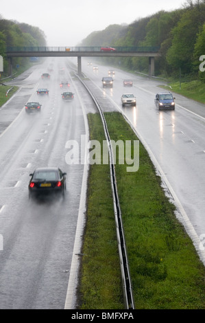 Le vetture che viaggiano a velocità sotto la pioggia sulla M2 in Kent, Inghilterra Foto Stock