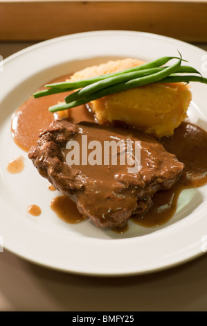 Brasato di manzo servita con purè di patate dolci e fagioli verdi a una cena formale a Santa Croce College di Oxford. Foto Stock