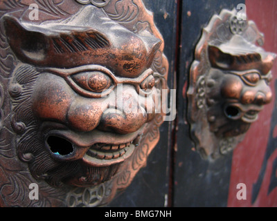 Bestia maniglie sagomate sul gate di un Hutong casa cortile, Pechino, Cina Foto Stock