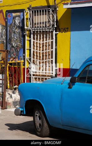 Vecchio Blu auto parcheggiate in strada con artwork dipinta su edifici al Callejon de Hamel, Havana, Cuba, West Indies, dei Caraibi e America centrale Foto Stock