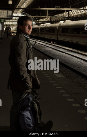Ritratto di un maschio di viaggio, abbigliamento invernale, sulla stazione ferroviaria Foto Stock
