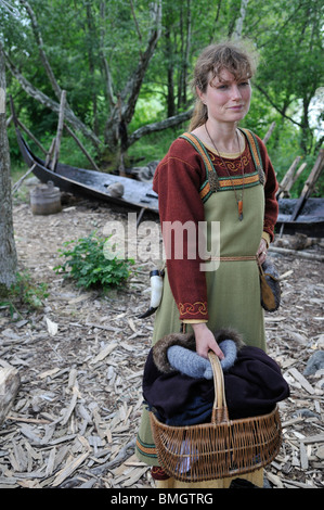 Donna in costume vichingo portando un cesto in città vichinga di Birka sull isola di Bjoerkoe, patrimonio mondiale dell UNESCO, Svezia Foto Stock