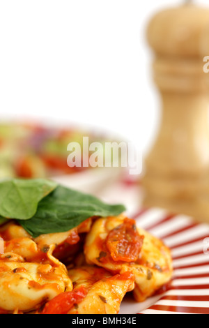 Cucinato al momento in italiano o in stile Mediterraneo autentico di Spinaci e Ricotta Tortelloni con insalata contro uno sfondo bianco con n. di persone Foto Stock