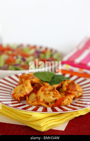 Cucinato al momento in italiano o in stile Mediterraneo autentico di Spinaci e Ricotta Tortelloni con insalata contro uno sfondo bianco con n. di persone Foto Stock