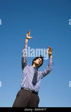 Uomo in camicia e cravatta raggiungimento di sky Foto Stock