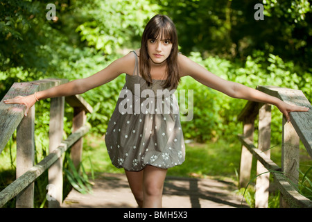 Teen girl in posa sul ponte di legno in posizione di parcheggio Foto Stock