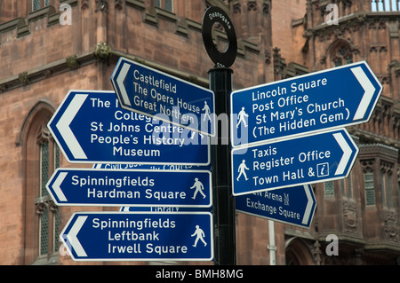 Informazioni/segnali di direzione Deansgate, Manchester,U.K.John Rylands Library in background. Foto Stock