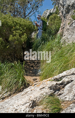 Nel corso di una escursione, un senior donna prendendo una pausa (La Maiorca). A Maiorca, randonneuse marquant une pausa durant une sortie. Foto Stock