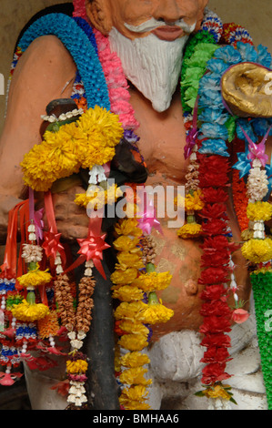 Statua buddista con una ghirlanda offerte presso il Wai Khru cerimonia , Wat Phra Bang , Divieto Tambol Gaew fa , Nakornpathom, Tailandia Foto Stock