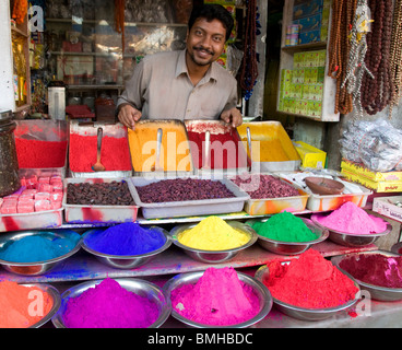 Un uomo vendita kumkum colorato in polvere in mercato Devaraja a Mysore, Karnataka, India. Foto Stock