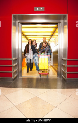 Famiglia proveniente al di fuori di un ascensore Foto Stock