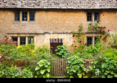 Tradizionale antica Cotswold stone casa di villaggio con luci con piombo, bifore e un affascinante frontale ricoperta Garden cottage Foto Stock