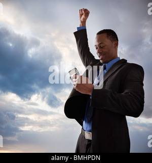 Happy businessman in possesso di un telefono cellulare Foto Stock