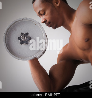 Uomo muscolare un sollevamento di pesi Foto Stock