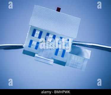 Casa modello che affonda in acqua Foto Stock