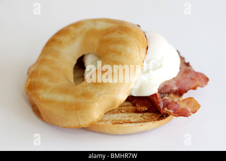 Uovo affogato e pancetta su un bagel Foto Stock