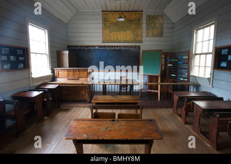 Una diciannovesima (XIX secolo (1800) classe con panche di legno, un pianoforte e una lavagna, Auckland, Nuova Zelanda Foto Stock