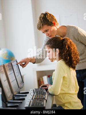 Docente aiutare lo studente nel laboratorio di computer Foto Stock