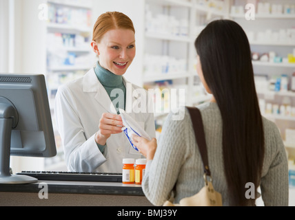 Il farmacista prescrizione dando al cliente Foto Stock