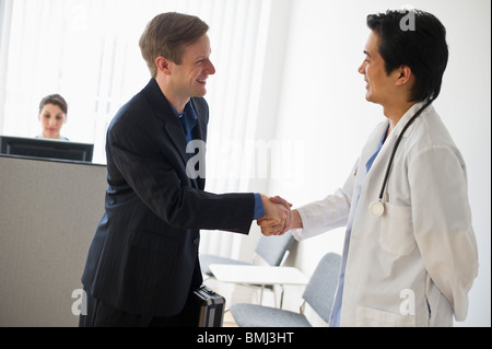 Venditore e medico stringono le mani Foto Stock