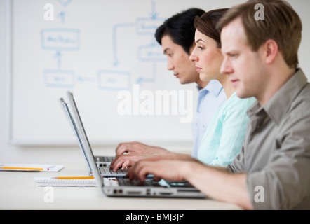 Adulti che lavorano sui notebook in aula Foto Stock
