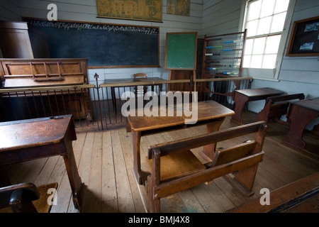 Una diciannovesima (XIX secolo (1800) classe con panche di legno, un pianoforte e una lavagna, Auckland, Nuova Zelanda Foto Stock