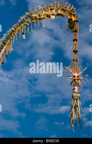 Decorative lungo i pali di bambù, localmente noto come 'penjor' costruita quando gli Indù Balinese celebrare Galungan e Kuningan giorno. Foto Stock