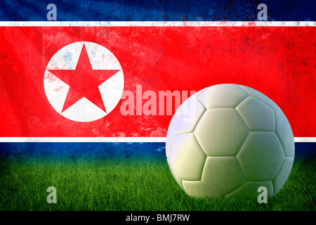 Grunge Corea del Nord bandiera sulla parete e pallone da calcio Foto Stock