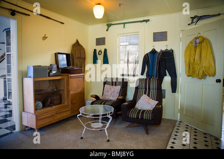 Mobili e attrezzatura subacquea in una casa sulla spiaggia da anni cinquanta ('50s house o 50's casa) Auckland, Nuova Zelanda Foto Stock