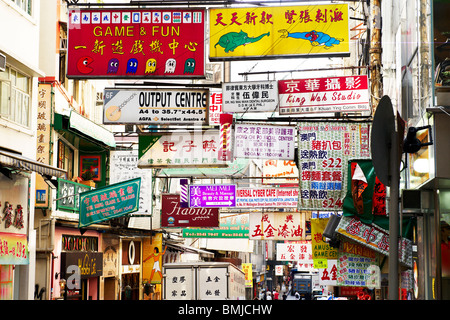 A Hong Kong street è riempito con banner pubblicitario sopra, che copre completamente il cielo. Il commercio è onnipresente. Foto Stock